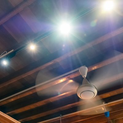 Ancient rotation fan on wood ceiling with light shining decoration at home